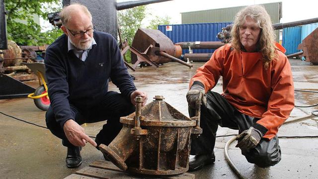 丹麥潛水員安德森（左）展示其打撈上來的U-78潛艇殘骸。