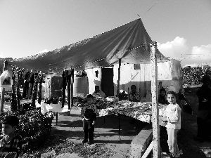 黎巴嫩一敘利亞難民營，難民支起攤鋪賣衣服掙錢。