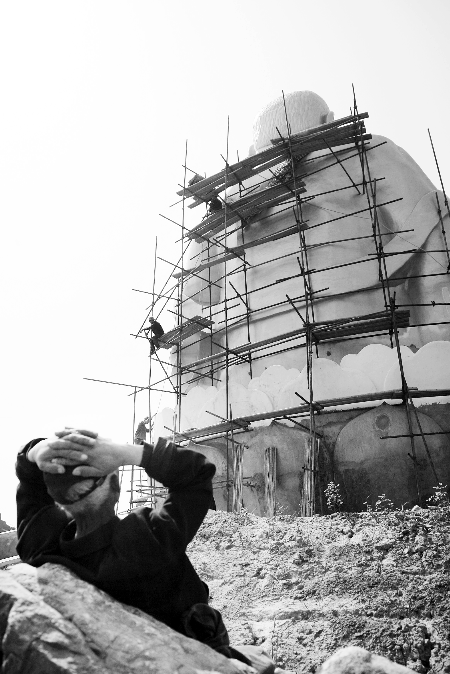 今年4月26日，工作人員將帆布蓋在“佛像”頭像上