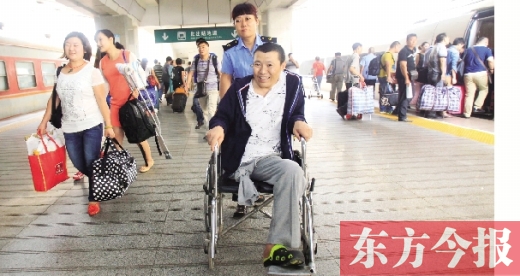 李剛手術(shù)后歸來(lái)，在車站工作人員幫助下走出鄭州火車站站臺(tái)  東方今報(bào)首席記者 張曉冬 攝