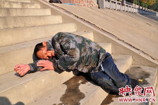 這名男子的衣服以及褲子全濕透了，水從衣褲里流出來，嘴里散發(fā)著濃烈的酒氣。