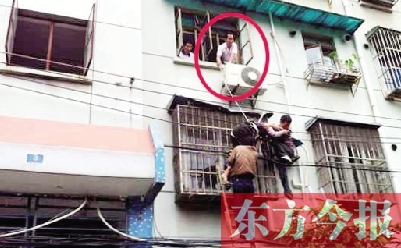 施救現(xiàn)場，劉鵬（圈內）先用繩子捆住老太確保安全 勞動報記者 郭娜 供圖