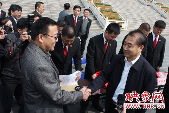 在新密市法院，省高院院長張立勇為拍得轎車的陳先生發(fā)放車鑰匙。