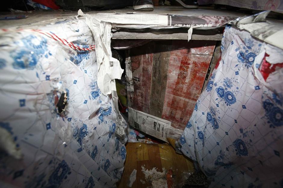 陳小龍在出租屋外，自行又圍起一堵圍墻，安裝了一個門。圍墻上都是豎起的鐵釘，外面堆著土，鄰居猜是從地底挖出來的。洞口就在床邊，0.5米見方，深約1.5米。洞口表面一塊紙板掩蓋，打開紙板跳入洞底，是一扇小木門，木門外有插銷，可以從外面鎖上。