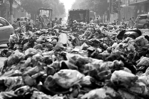 垃圾堆滿整個路口，環(huán)衛(wèi)工人們正在清理