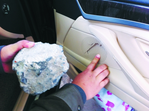 “飛”進(jìn)寶馬車內(nèi)的大石塊,將寶馬車的車門內(nèi)飾板砸爛。