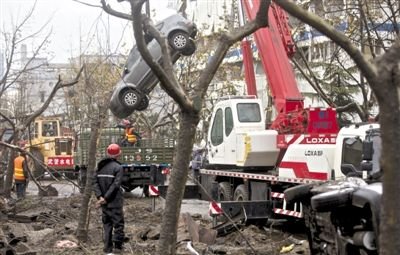 輸油管道爆炸后，搶修人員將被炸毀的車輛運(yùn)出現(xiàn)場。