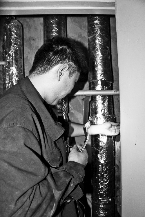 苗師傅一邊進(jìn)行維修，一邊用耳機(jī)接聽市民的電話。