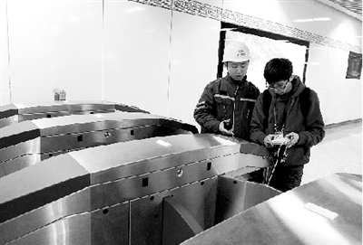 昨天上午，體育中心站，工作人員正在對進出站閘機進行調(diào)試。