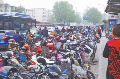 省人民醫(yī)院北門，路邊的公交站牌處停滿非機(jī)動(dòng)車，上、下客只能在快車道上。