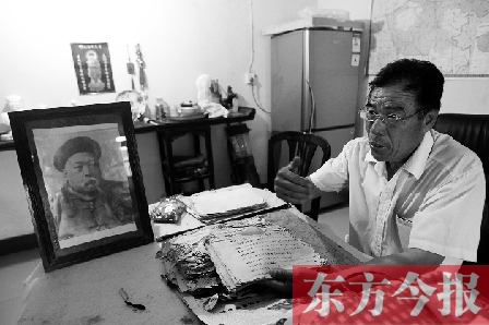 　魏樹紹手拿《物權(quán)法講義》手稿，在講訴先祖書寫“物權(quán)法”的歷史（相框里就是魏聯(lián)奎）