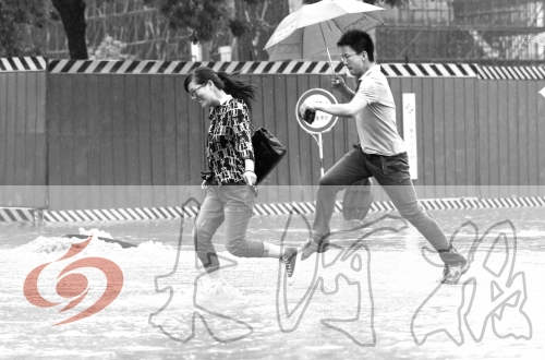 鄭州經(jīng)三路與北環(huán)交叉口處，積水較深，行人們不得不“練輕功”。 記者 白周峰 攝影