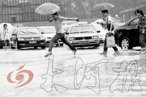 鄭州經(jīng)三路與北環(huán)交叉口處，積水較深，行人們不得不“練輕功”。 記者 白周峰 攝影