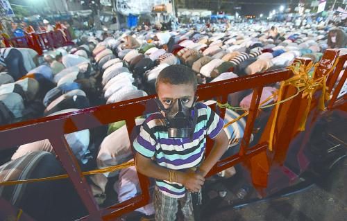 當(dāng)?shù)貢r(shí)間28日晚，在埃及開羅納賽爾城，一名小男孩頭戴防毒面具參加穆兄會(huì)的集會(huì)示威。