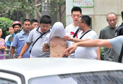 昨日，成都警方抓捕時與毒犯發(fā)生槍戰(zhàn)。一名男犯罪嫌疑人被警方押出。