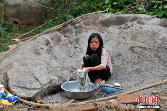 8月9日，云南巧家紅石巖村，10歲的劉鑫蕊在洗自己的衣服