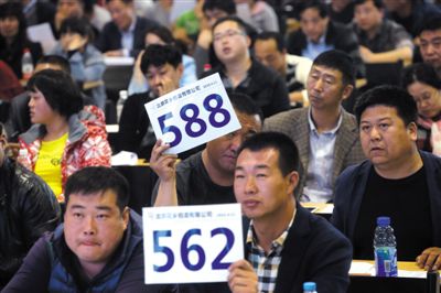 昨日，拍賣現(xiàn)場競拍者舉牌競拍。新京報記者