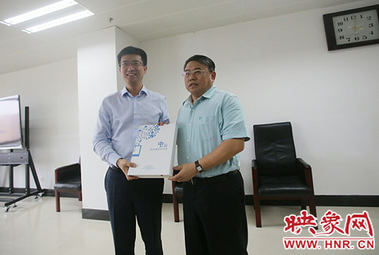 阿里云計(jì)算總裁胡曉明向河南省新聞出版廣電局局長朱夏炎遞交《中原云平臺(tái)交付手冊》。