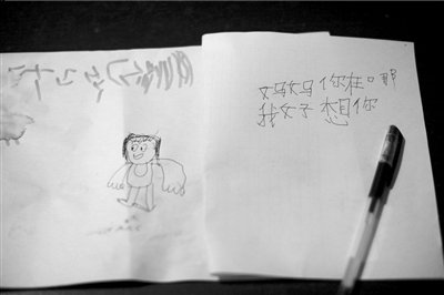 名叫袁明燕的小姑娘用筆在紙上不斷寫“媽媽”二字。