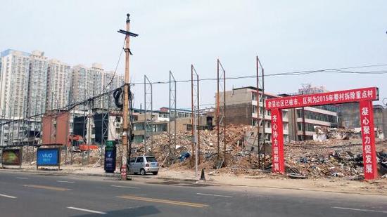 015年5月31日，在社區(qū)干部的帶頭拆遷下，親賢社區(qū)的“城中村改造”拉開帷幕。由于前期“清產(chǎn)核資”及補(bǔ)償標(biāo)準(zhǔn)等因素，拆遷改造工作推進(jìn)并不順利。圖為位于體育西路東側(cè)集體所有的商鋪率先被拆遷完畢，用于遮擋的圍擋正在施工中。（拍攝：2015年9月16日）