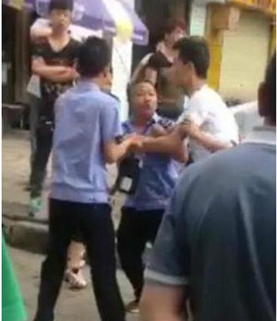 付某（右）與城管執(zhí)法人員廝打在一起。