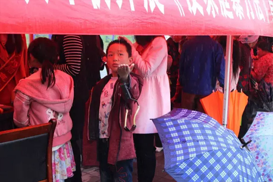 因為雨下的太大，小男孩玩起了接水游戲。