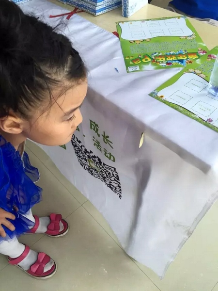 一只蝴蝶飛到小蝸牛的旗子上，小朋友看得入神啦~