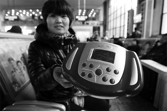 火車站候車室，李女士向記者展示她準(zhǔn)備孝敬父母的按摩儀