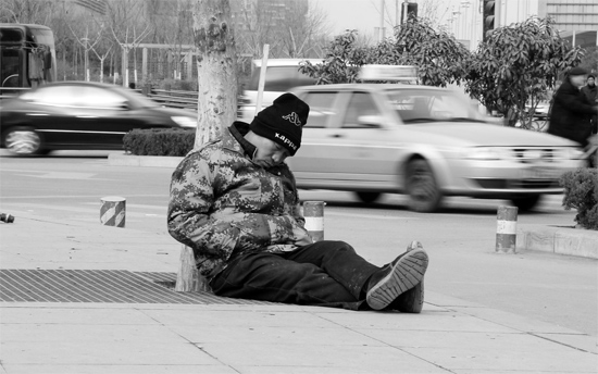 2月2日，鄭州市中州大道農(nóng)業(yè)路立交橋下，50歲的王文德打算在臨近春節(jié)前再接些零活兒，由于疲憊，他睡著