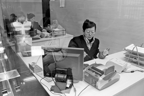 2月16日，鄭州市自來水總公司鄭東新區(qū)一營業(yè)廳，柜臺內(nèi)工作人員正在為市民辦理業(yè)務(wù)