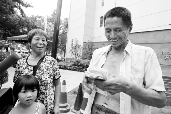 昨日，鄭州市明達(dá)路與豐慶路交叉口西300米路南，來自中牟的瓜農(nóng)拿到西瓜款，笑開顏東方今報(bào)記者袁曉強(qiáng)