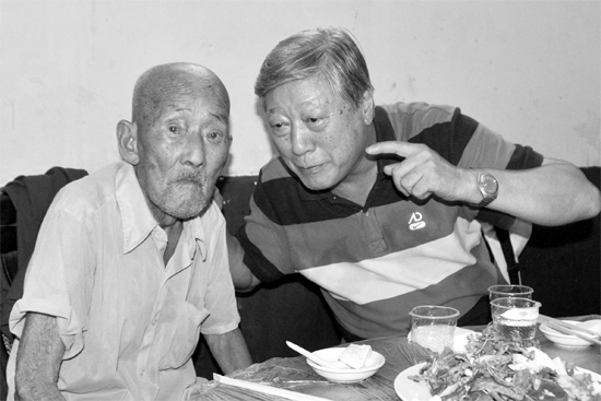 昨日，來自北京的英雄后代胡冠軍（右）專門趕到西平縣看望抗戰(zhàn)老兵孫殿修老人