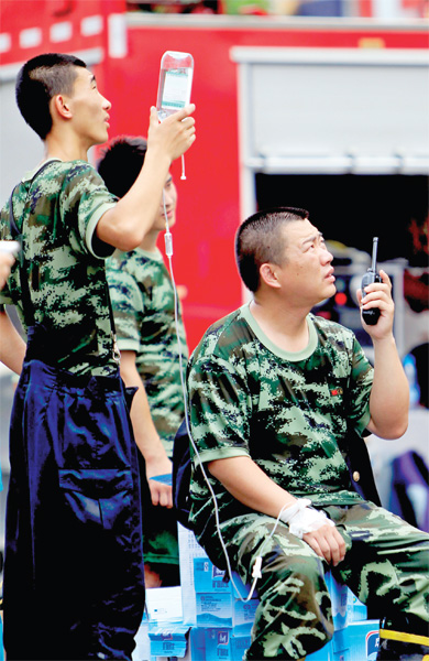 火場(chǎng)外，被消防戰(zhàn)士稱為“李大隊(duì)”的救援人員掛著吊瓶現(xiàn)場(chǎng)指揮