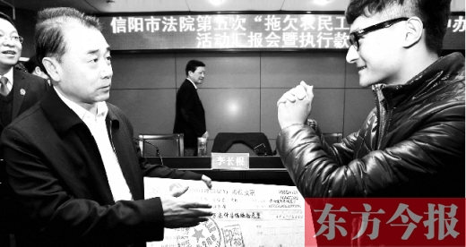 張立勇將依法執(zhí)行回來的農(nóng)民工工資發(fā)放給案件當(dāng)事人游昌華，游昌華施以中國傳統(tǒng)作揖禮答謝