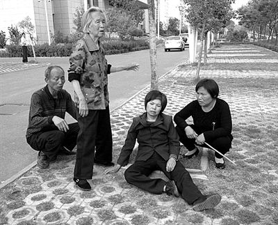 2013年4月28日，平頂山市市政府附近，受害者郭小蕊（化名）的家屬鳴冤，郭小蕊的母親杜玉花癱坐在地上。