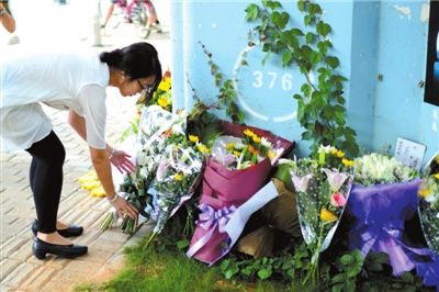 6月8日下午，記者來到廈門公交車爆炸事發(fā)現(xiàn)場橋下，附近已聚集了十幾個自發(fā)前來悼念的市民。橋墩下排放了一圈或黃或白的菊花，還有玖瑰、百合等。