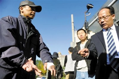 常林鋒在法院外展示雙手，他稱被燙傷的手因刑訊逼供且未得到及時(shí)救治