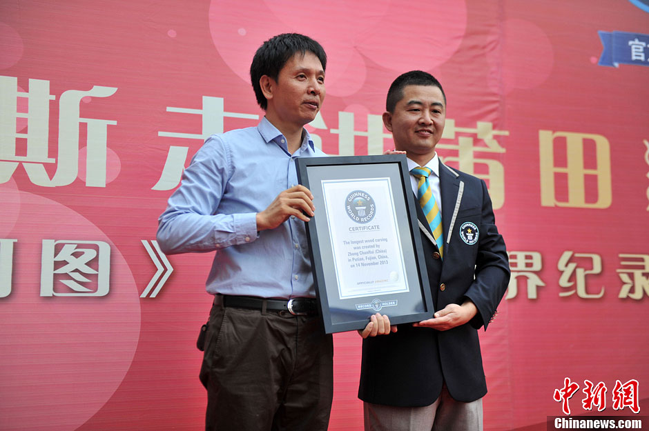 圖為世界吉尼斯認證官為鄭春輝（左）頒發(fā)證書。呂明 攝