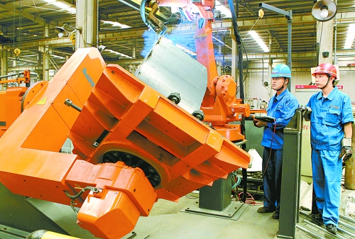 圖為龍工集團中原公司的職工正在操作機器人焊接裝載機。