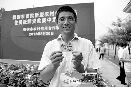 領(lǐng)到貸款，農(nóng)民開心地笑了。