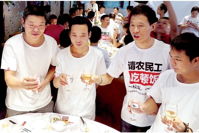 活動(dòng)發(fā)起人張楠（右二）給農(nóng)民工敬酒。