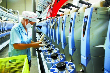 7月3日，在鄧州市永泰棉紡有限公司電腦控制全自動紡紗車間，紡織工人正在生產(chǎn)棉紗。