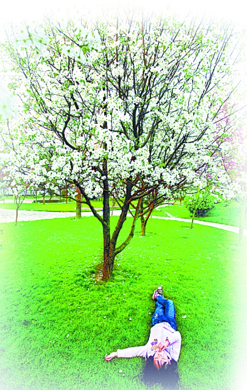 　孩子愜意地躺在社區(qū)內(nèi)的草坪上。