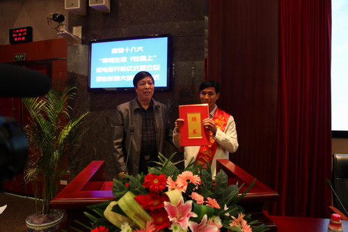 河南平頂山魯山縣電視臺的記者張朝岑，接過了河南電視臺9頻道總監(jiān)張克宣遞上的聘書。