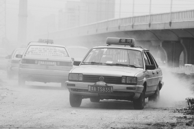 施工的道路上，車輛通過塵土飛揚。