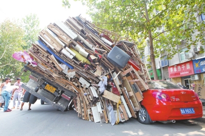 紅色小轎車被砸，卡在路邊動彈不得。