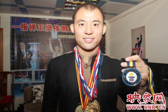 樊偉鵬向大家展示自己剛獲得的吉尼斯獎(jiǎng)牌。
