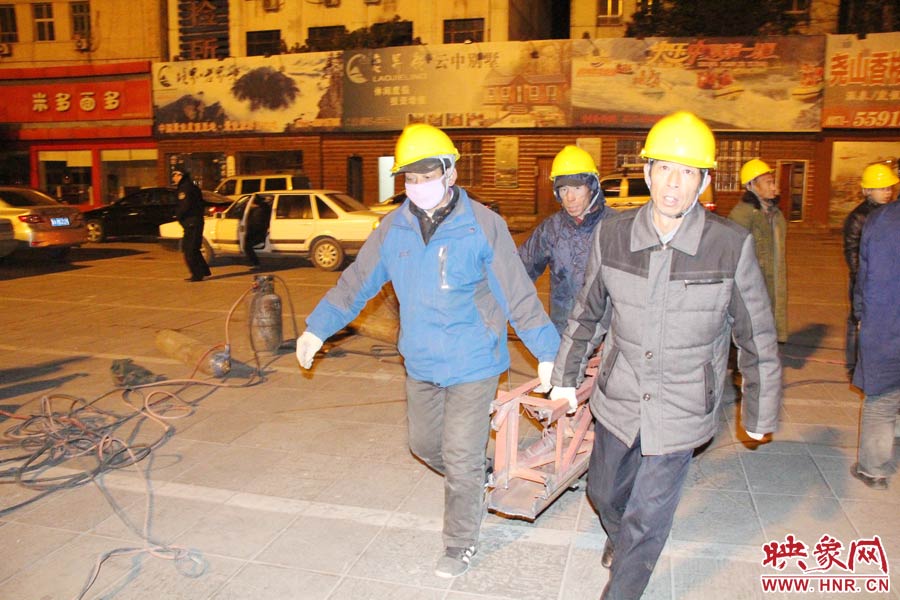 23點(diǎn)56分，第一塊兒廣告牌已經(jīng)分割完畢，地面上的20多名工人將拆除下來的鋼件撞車運(yùn)走。