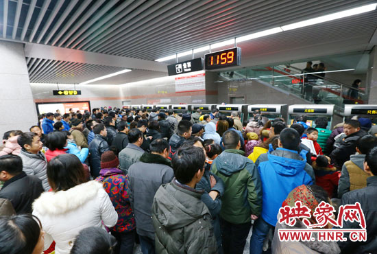 地鐵開通首日，上午十一點五十九分，紫荊山地鐵站售票機前擠滿了買票的市民。