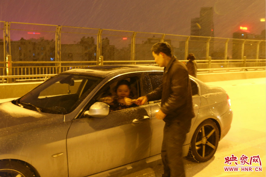 “推車人”幫助一輛車上坡后，收取“勞務(wù)費(fèi)”。